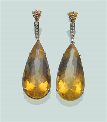 Lot 570 - A Pair of Drop Earrings, a trio of yellow sapphires surmounts a diamond set bar, which suspends...