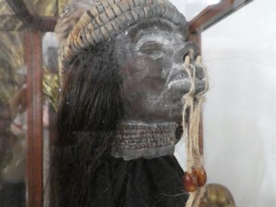 Lot 205 - Two Reproduction Shrunken Heads, applied with hair, each approximately 20cm high; An Ebonised...