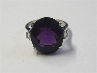 Lot 579 - An 18 Carat White Gold Amethyst and Diamond Ring, an oval cut amethyst between a pair of...