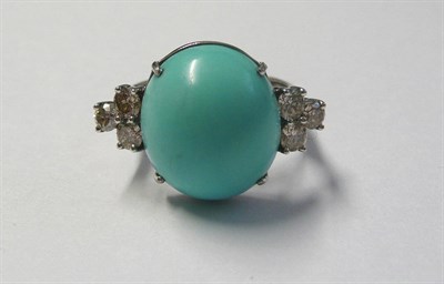 Lot 580 - A 14 Carat Gold Turquoise and Diamond Ring, an oval cabochon turquoise between a trio of round...