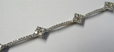 Lot 594 - An 18 Carat White Gold Diamond Bracelet, clusters of four round brilliant cut diamonds are...