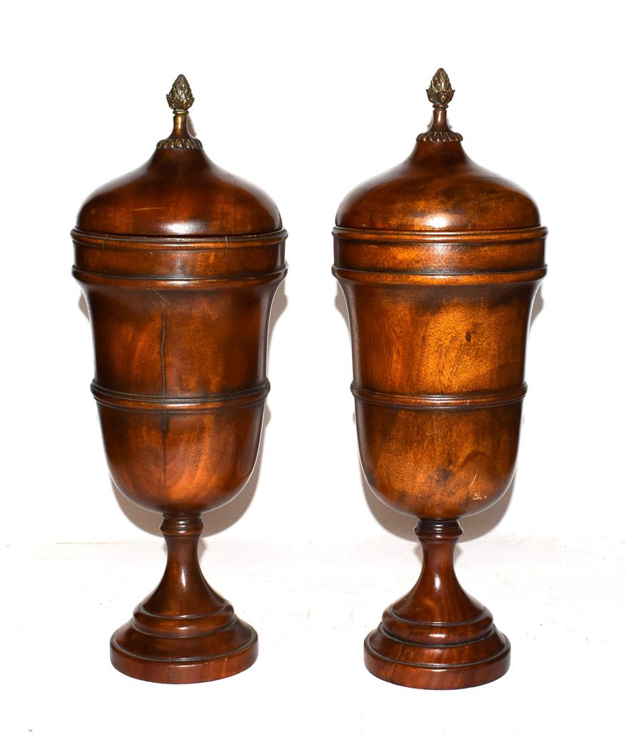 Lot 30 - Theodore Alexander, a pair of modern turned hardwood urns and covers with patinated metal finial's