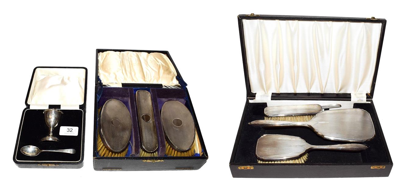 Lot 32 - Two silver-mounted brush sets and a cased silver egg cup and spoon