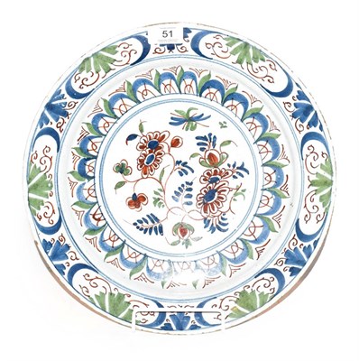 Lot 51 - An English Delft plate, mid 18th century, painted in colours with a central flower spray within...