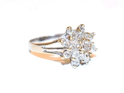 Lot 117 - A diamond cluster ring, the raised central round brilliant cut diamond within a double border...