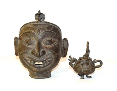 Lot 161 - A bronze mask of a Buddha, modelled with serene expression, 23cm high together with a miniature...