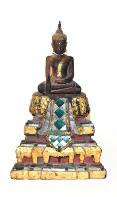 Lot 165 - A carved hardwood and parcel-gilt seated Buddha, probably 19th century, on tiered gilt and mirrored