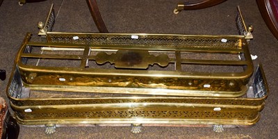 Lot 185 - Three Victorian brass fire fenders, including a pierced example on paw feet, all 122cm wide...