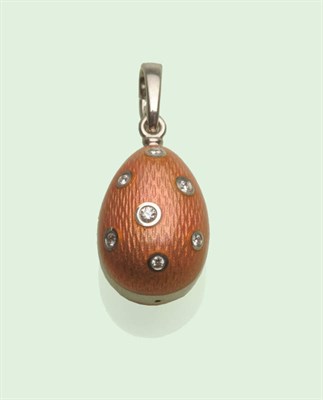 Lot 619 - A Modern Fabergé Egg Pendant, guilloche enamelled in peach, with seven round brilliant cut...