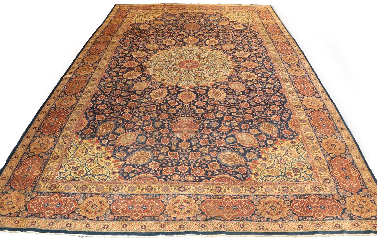 Lot 1086 - Large Tabriz carpet, north west Iran, the indigo field of vines around an ivory roundel...