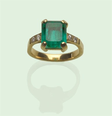 Lot 627 - An Emerald and Diamond Ring, the step cut emerald with truncated corners, in a yellow four claw...