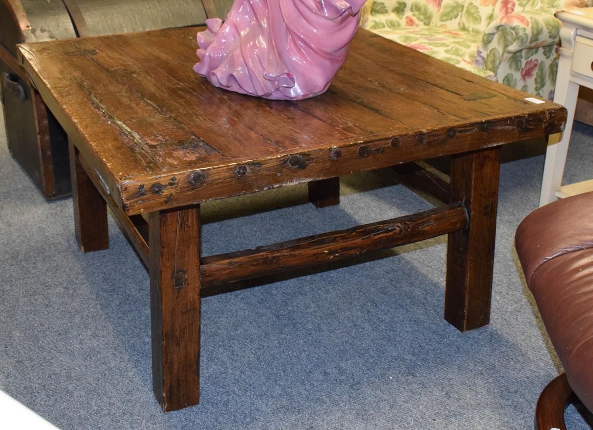 Lot 1095 - A rustic elm plank top coffee table composed of period elements, 93cm by 88cm by 51cm
