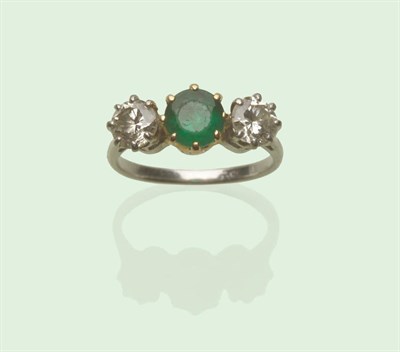 Lot 629 - An Emerald and Diamond Three Stone Ring, the emerald in a yellow claw setting, a round...