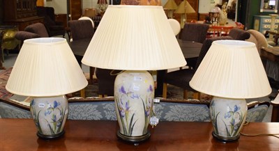 Lot 1118 - Three decalomania glass table lamps decorated with irises, comprising a pair 26cm and a larger...