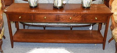 Lot 1119 - A modern hardwood four drawer two tier sideboard, inside drawer with attached label inscribed...