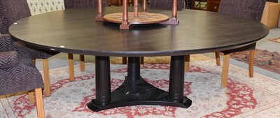 Lot 1143 - An imposing hardwood circular dining table, raised on three substantial tapering columns joined...