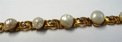 Lot 633 - A Pearl and Diamond Bracelet, baroque pearls spaced by scroll links, each with an old cut...