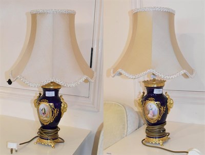Lot 1181 - A pair of Sevres style gilt metal and painted porcelain vase form table lamps, each with rams...