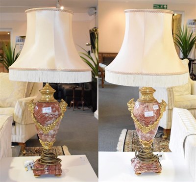 Lot 1182 - A pair of gilt metal mounted rouge marble table lamps with satyr mask handles and floral swags,...