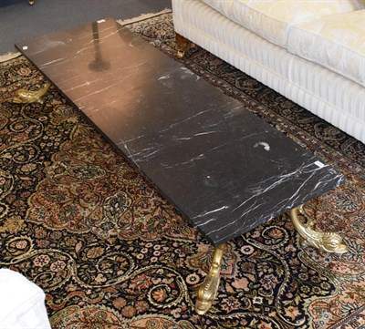 Lot 1186 - A rectangular marble top coffee table with gilt metal dolphin form feet, 160cm by 51cm by 29cm
