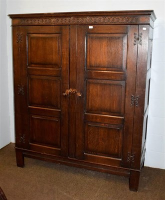 Lot 1207 - An 18th century style linen cupboard, with carved pediment and panelled doors, 159cm by 64cm by...