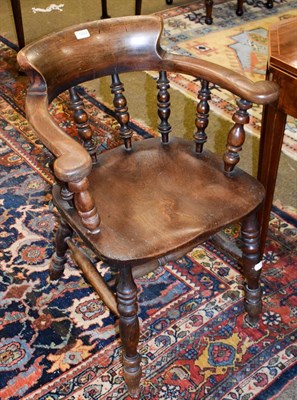 Lot 1242 - A late 19th century elm smokers bow armchair