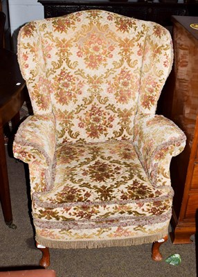 Lot 1256 - A 20th century wing back armchair