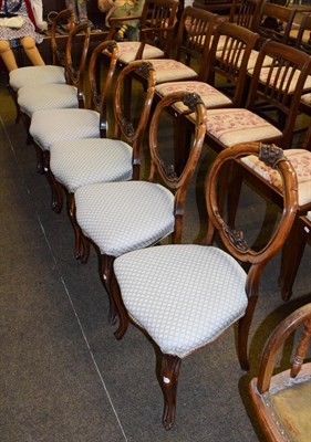 Lot 1260 - A set of six Victorian carved walnut balloon back chairs