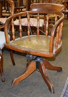 Lot 1261 - An Edwardian oak swivel office chair with applied label