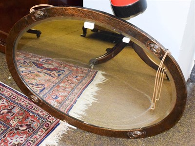 Lot 1308 - An Arts & Crafts oval planished copper wall mirror, 83cm by 58cm