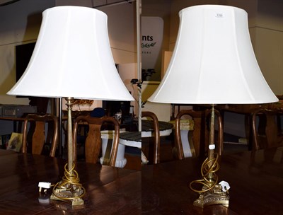 Lot 1325 - A pair of gilt brass table lamps, the tapering reeded supports on hipped legs and paw feet,...