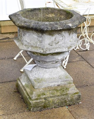 Lot 1336 - A weathered stone font form planter, the octagonal bowl with Gothic decoration 64cm by 76cm high
