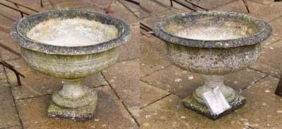 Lot 1337 - A pair of composition garden urns with part gadrooned bodies, each 66cm diameter by 46cm high