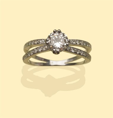 Lot 653 - A Diamond Solitaire Ring, a round brilliant cut diamond in a white claw setting to forked...