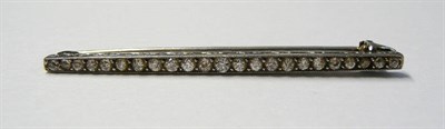 Lot 677 - A Diamond Bar Brooch, the old cut diamonds in white claws to a mount with engraved sides, total...