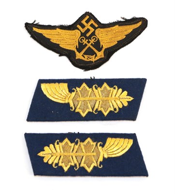 Lot 94 - A German Third Reich Air Sea Rescue Cloth Insignia, the black cloth field embroidered with a...