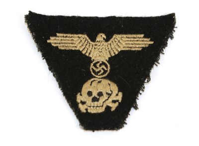 Lot 101 - A German Third Reich Waffen SS Trapezoid Cap Insignia, the black wool field with cotton backing...