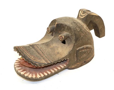 Lot 176 - A 20th Century Mambila Dog Head Mask, Cameroon, carved in wood covered in brown, cream and red...