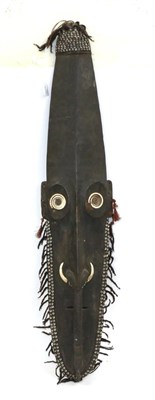 Lot 184 - A Dyak Ebony Spirit Mask, of elongated oblong formwith inset coiled bone ring eyes, the hooked nose