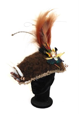 Lot 187 - A 21st Century Huli Wig, Papua New Guinea, of curly brown human hair decorated with feathers...