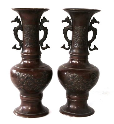 Lot 218 - A pair of Japanese Meiji period bronze twin handled vases decorated in relief with flowers and...