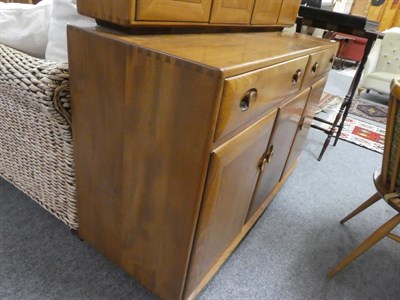 Lot 1055 - A Ercol light elm sideboard 136cms by 47cms by 125cms