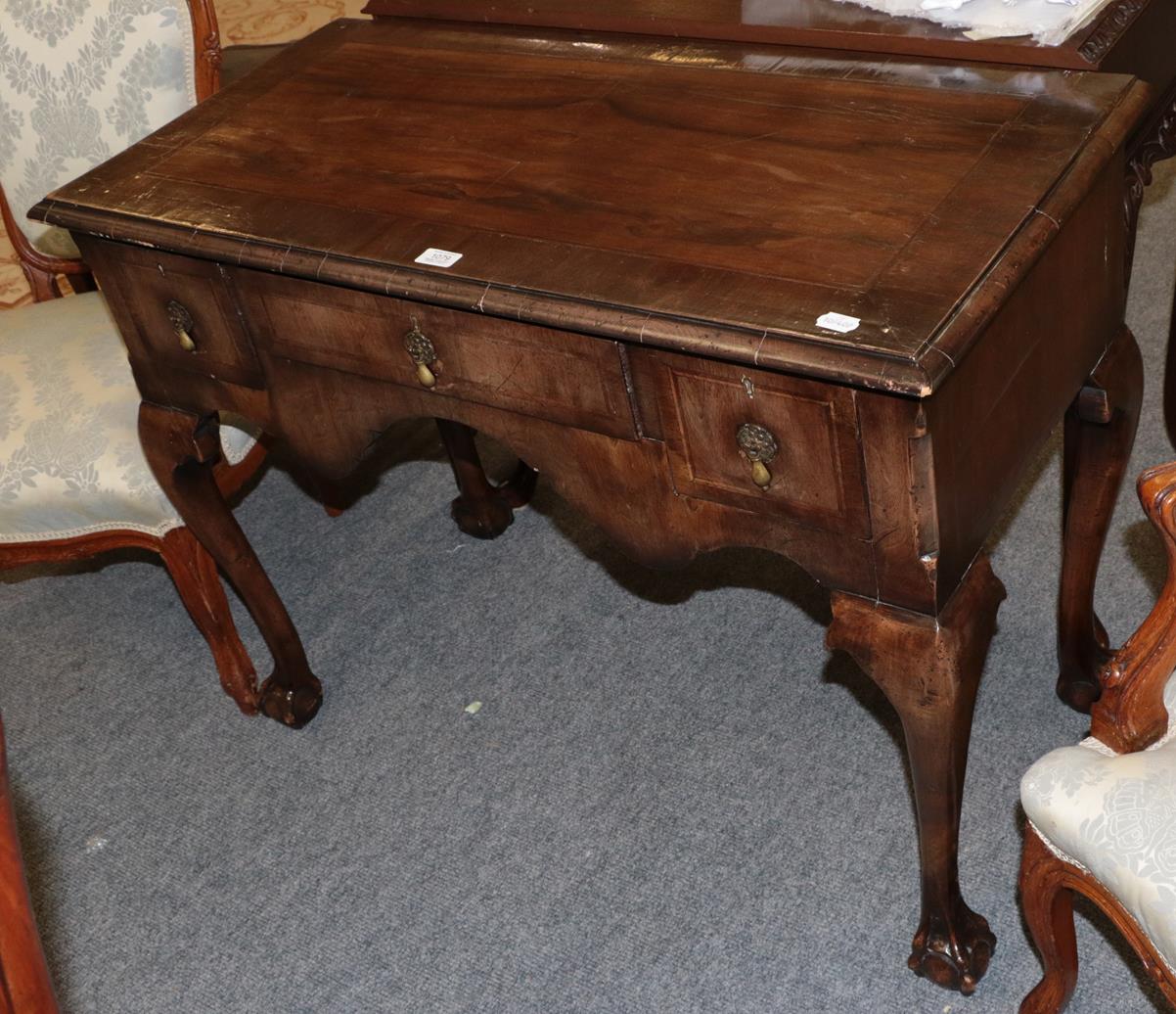Lot 1079 - A George III cross banded mahogany lowboy on ball and claw feet 99cm by 48cm by 76cm