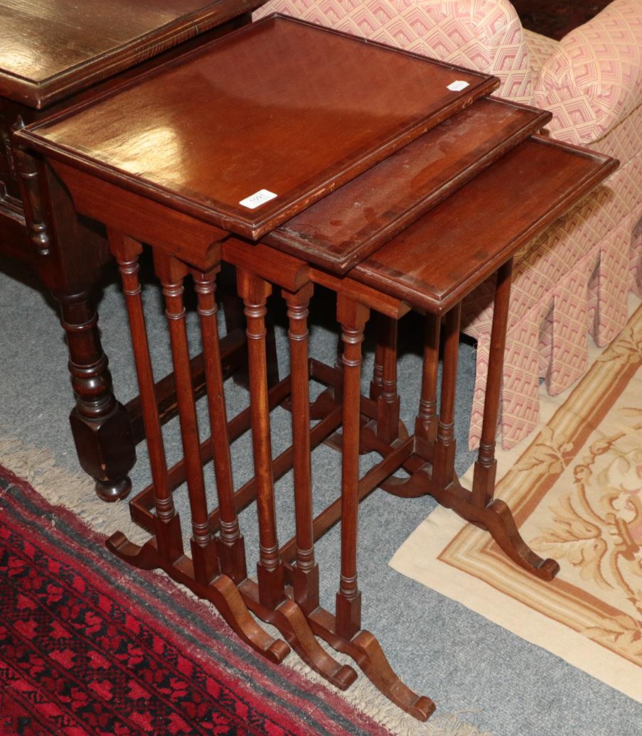 Lot 1091 - A nest of three cross banded mahogany spider leg tables 48cm by 38cm by 74cm (largest)