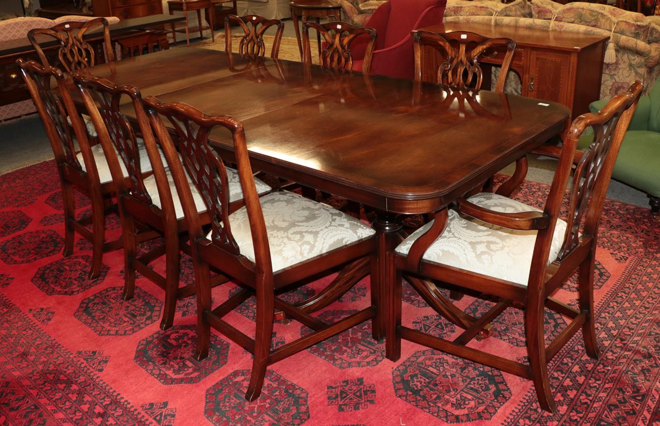 Lot 1094 - A reproduction twin pillar mahogany dining table 245cm by 104cm by 77cm together with a...