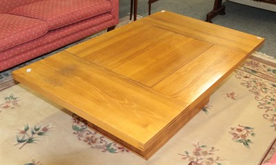 Lot 1101 - A modern light oak pedestal coffee table with central sliding compartment 140cm by 85cm by 45cm