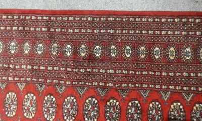 Lot 1122 - A Lahora 'Bukhara' rug , the claret field with rows of guls enclosed by multiple borders, 280cm...