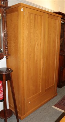 Lot 1151 - A bespoke modern oak double wardrobe fitted with a base drawer 128cm by 64cm by 210cm