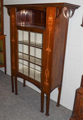 Lot 1182 - An Art Nouveau leaded glazed and marquetry inlaid mahogany display cabinet, with an overhanging...