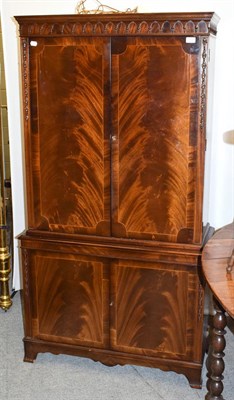 Lot 1198 - A reproduction mahogany cocktail cabinet with mirrored interior, 88cm by 36cm by 170cm
